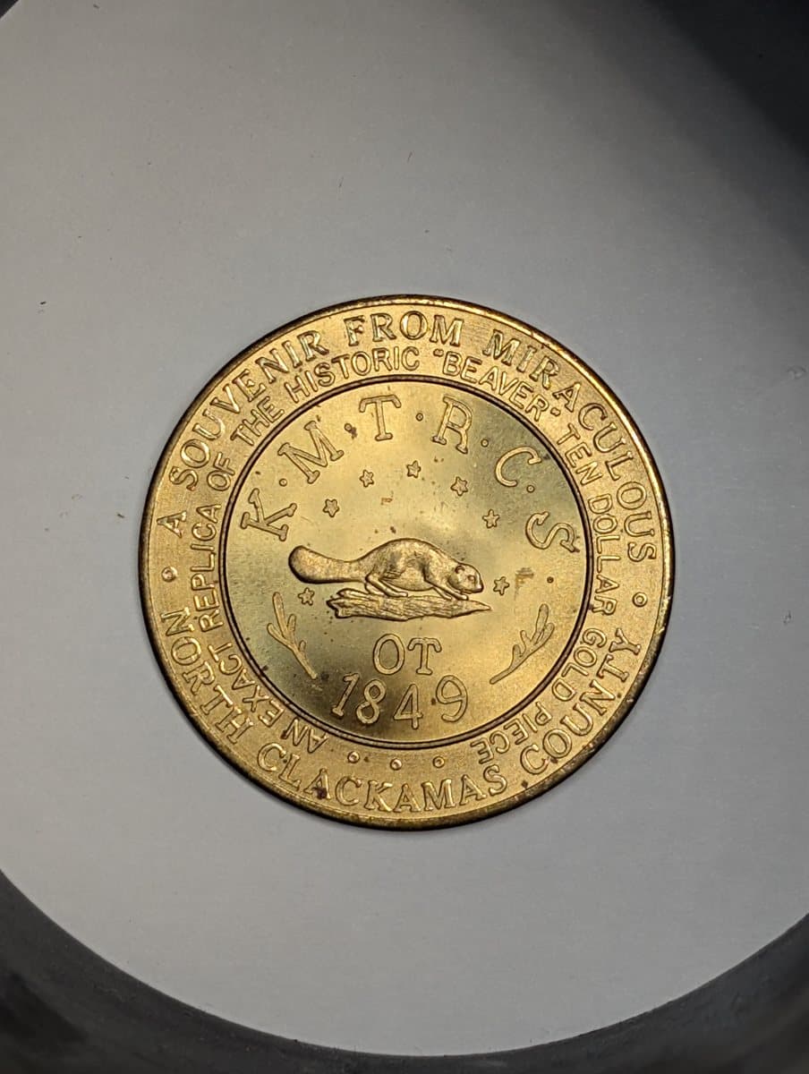 A phone photograph of a 1959 Oregon centennial so-called dollar on a plain surface, before the background was removed
