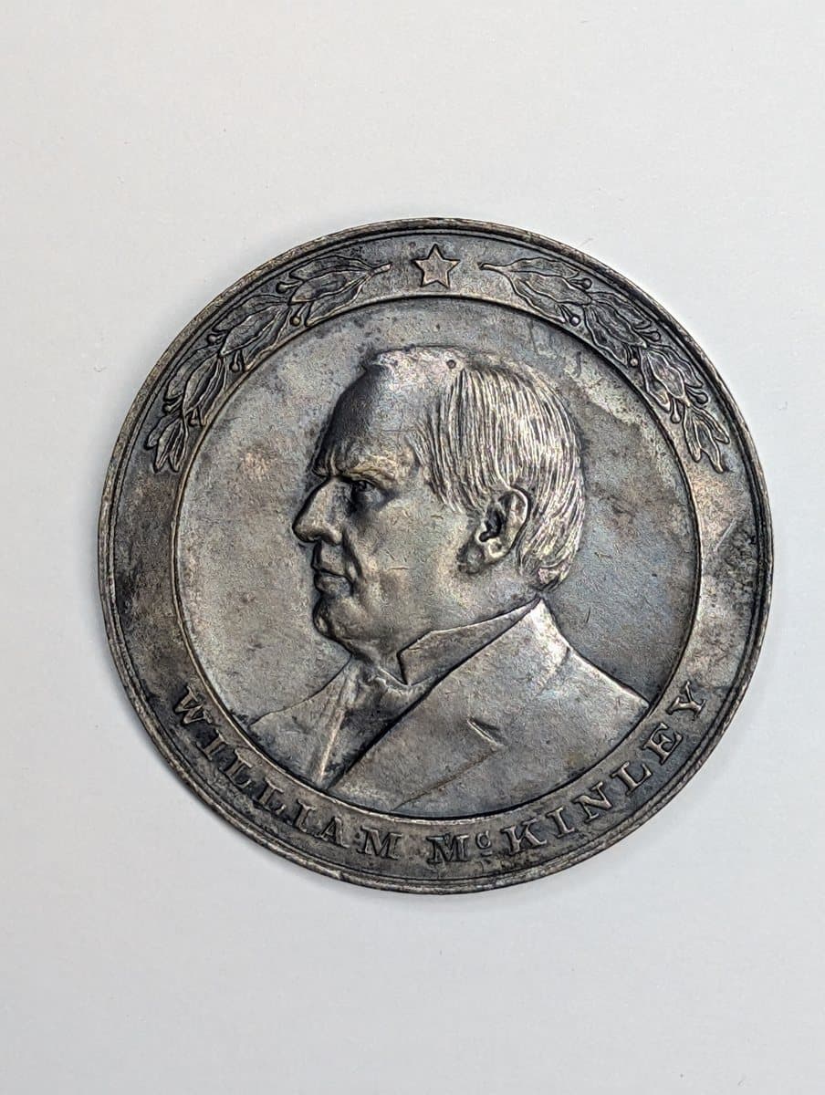 A phone photograph of a 1907 McKinley memorial dedication medal, before the background was removed