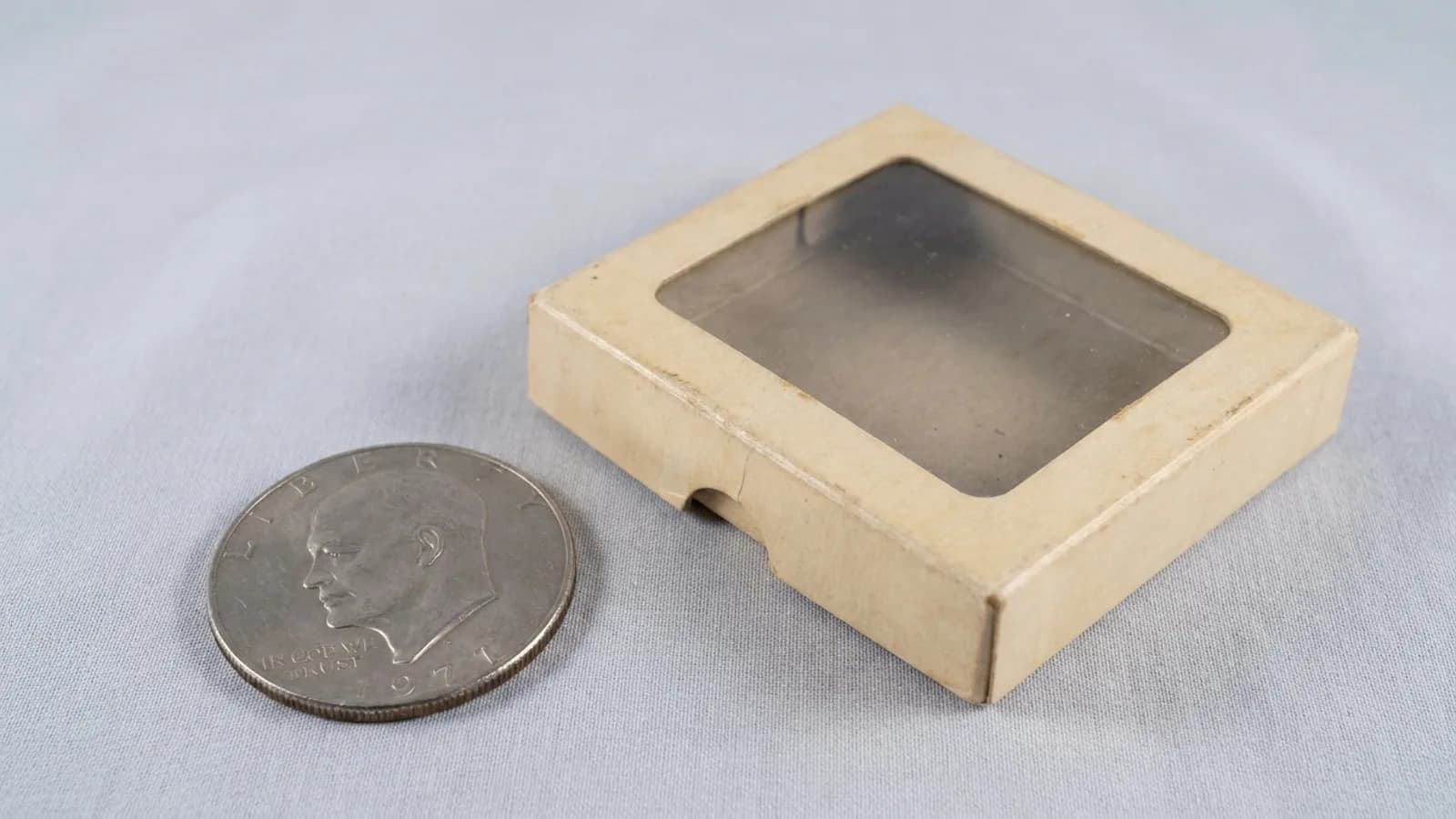 An Eisenhower dollar beside its original Mint collector packaging