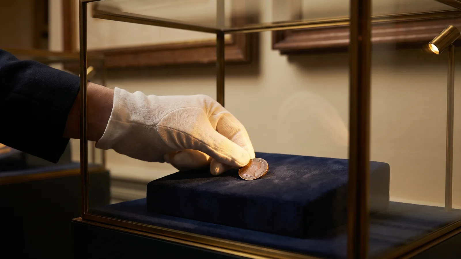 A gloved hand placing a token into a display case
