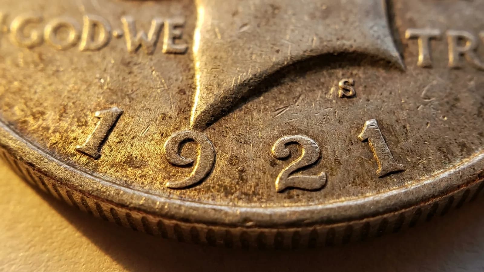 A Peace silver dollar showing the date and mint mark area collectors check