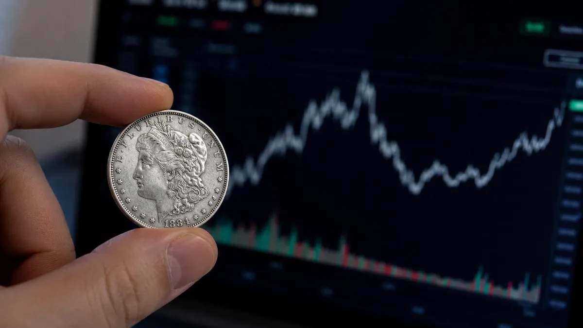 A coin dealer checking a silver coin against a live spot price screen