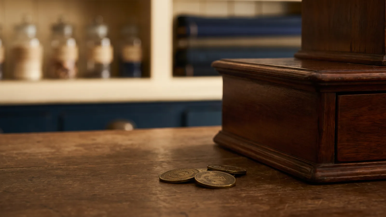 Brass trade tokens beside an antique cash drawer