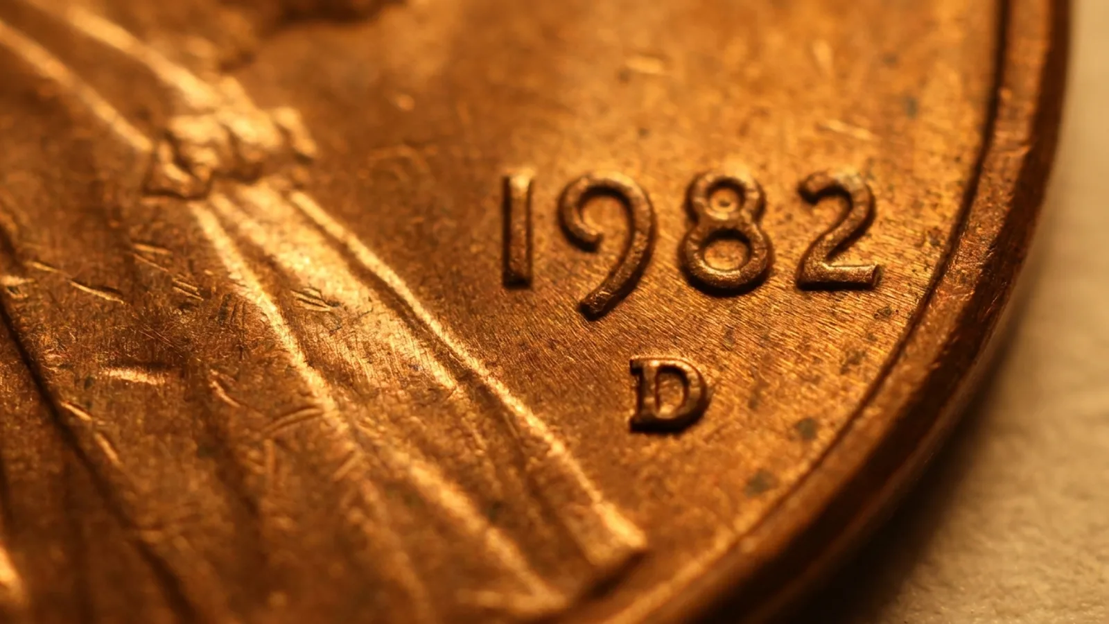 A close view of a coin's date and the small mint mark letter beside it