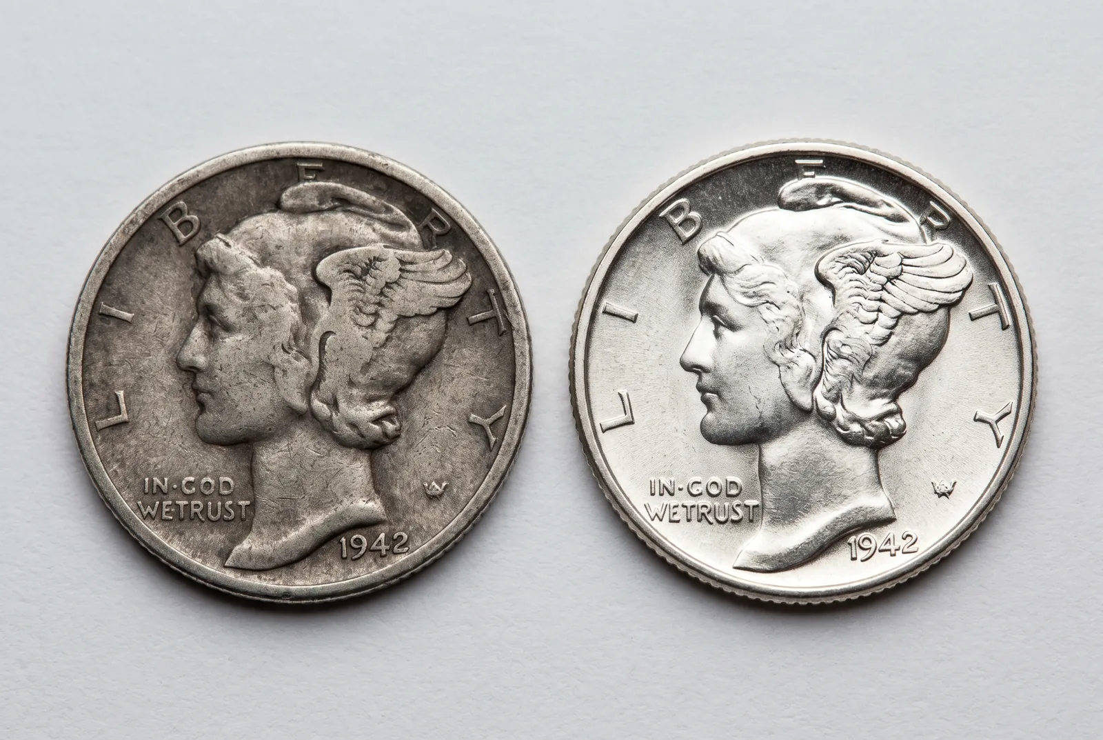 A worn circulated coin beside a lustrous mint-state example of the same type