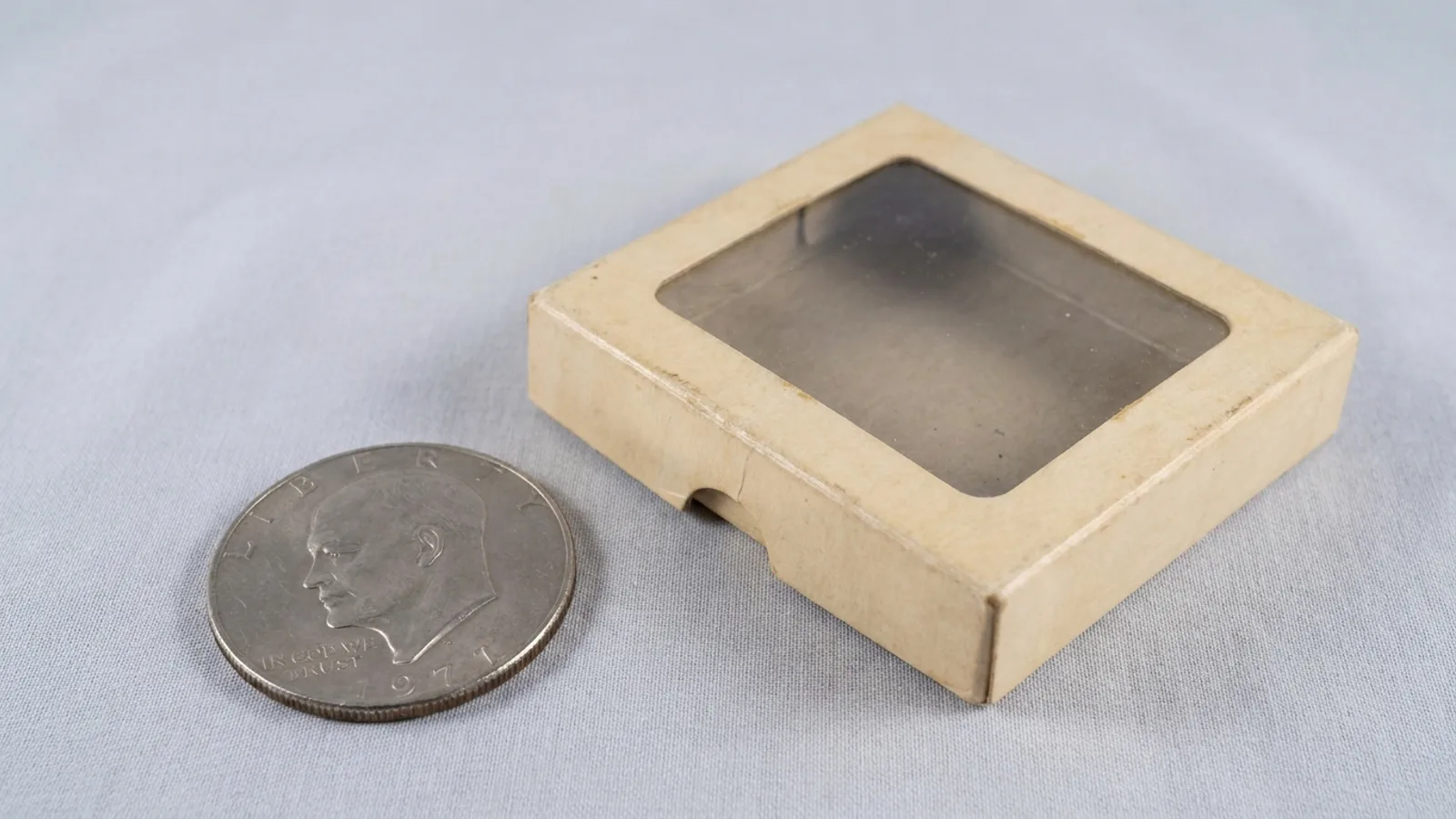 An Eisenhower dollar beside its original Mint collector packaging